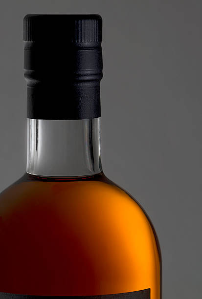 istock bottleneck and bottle cap with golden Cognac inside 472911646