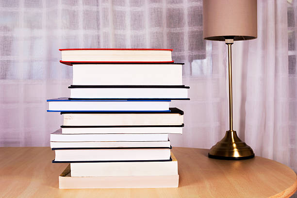 istock Stack of books and a lamp on the table 472917358