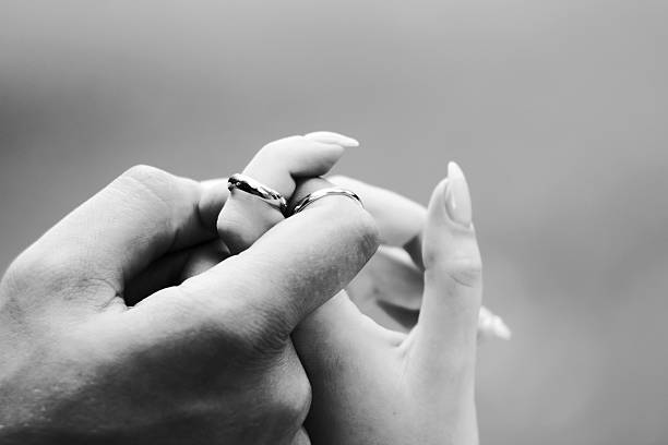 istock Wedding rings on fingers newlyweds 472920784