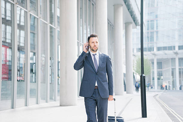 istock Businessman On His Cell Phone With Suitcase 472924076