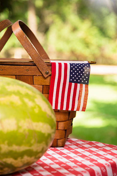 istock Whole watermelon outdoors on picnic table. American flag. Summer. 472924682