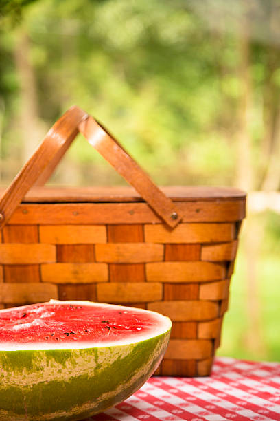 スライスのスイカ屋外でのピクニックテーブルを配しております。夏ます。バスケットます。 - picnic watermelon tablecloth picnic table ストックフォトと画像