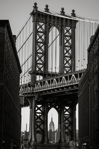 The Iconic Manhattan Bridge illuminated by the setting sun with the Empire State Building in the foreground. 