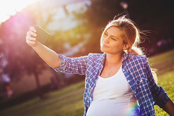 istock Pregnant woman taking selfie 472927994