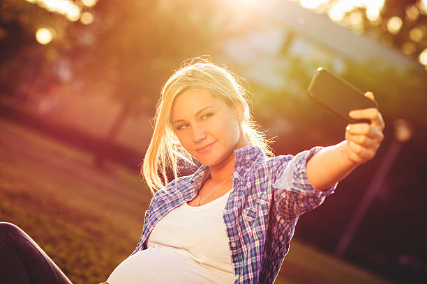 istock Pregnant woman taking selfie 472930688