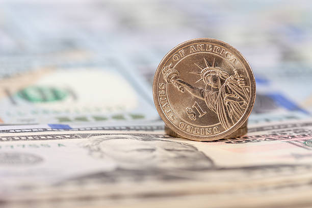 istock One American dollar coin over banknotes 472932928
