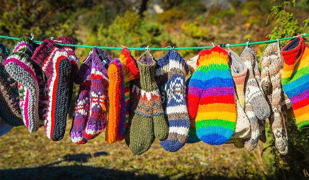 arcobaleno di woollen muffole guanti e calze appeso sulla linea - sock wool multi colored isolated foto e immagini stock