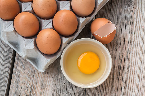 istock Eggs and Egg yolk in paper tray on wood 472942186