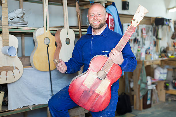 istock Craftsman holding unfinished guitar 472945268