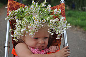 Little girl in a wreath of daisies