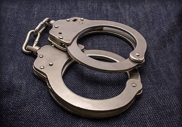 istock steel handcuffs  on jeans 472949780