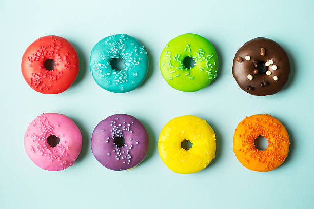 istock Colorful glazed donuts with sprinkles on a blue background 472954636