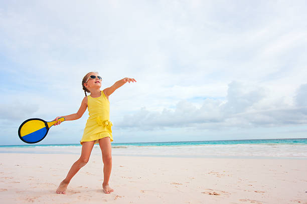 Little girl playing beach tennis stock photo