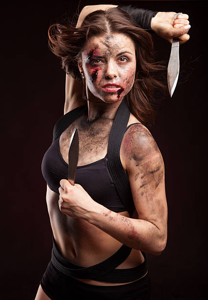 istock Killer woman with knife. Posing in studio. 472963254
