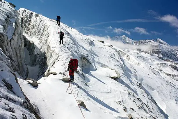 group of climbers on rope on glacier - sunny day on mountain