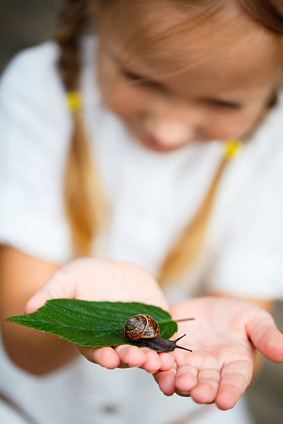 istock Little girl and snail 472967234