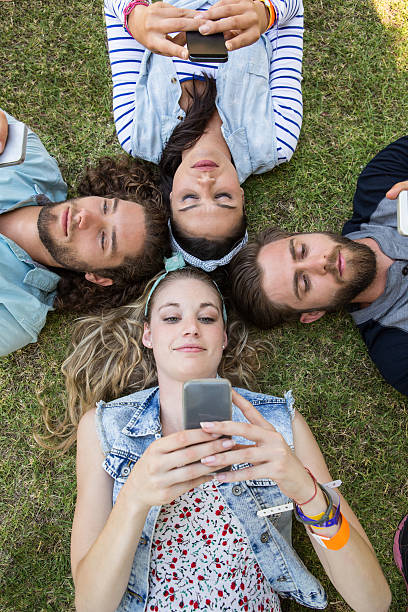 istock Happy friends lying on the grass 472970456