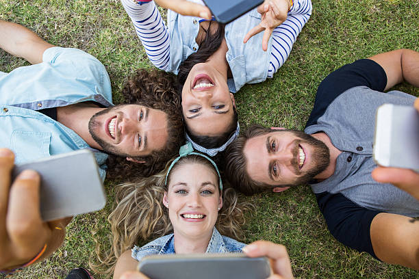 istock Happy friends lying on the grass 472970458