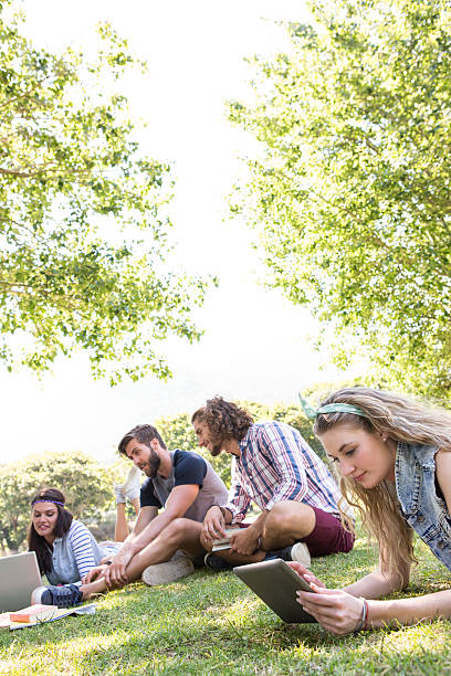 istock 4 young people hanging out on a sunny lawn with laptops 472970484