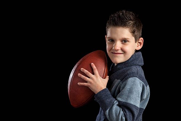 istock Young Boy Holding Football Like Quarterback 472974534