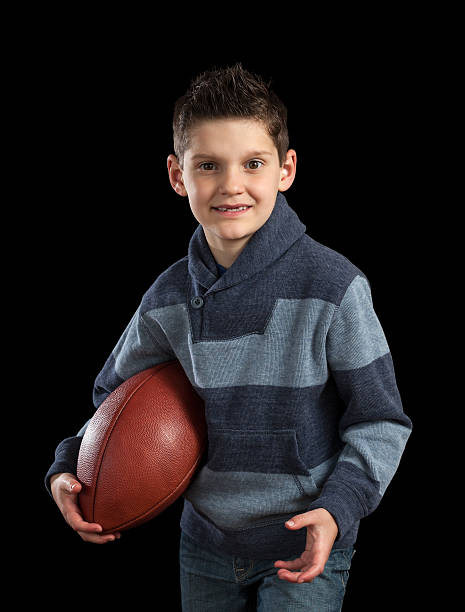 istock Young Boy Holidng Football Like Running Back 472974542