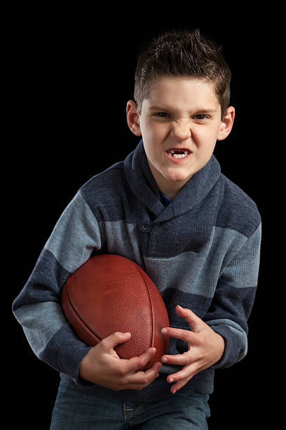 istock Boy Holidng Football and Making Scary Face 472974544
