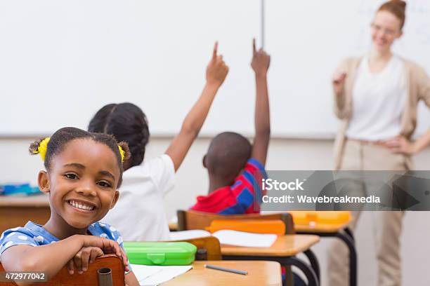 A Little Girl Sitting In A Classroom With A Teacher Stock Photo - Download Image Now