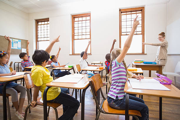 istock Pupils raising hand in classroom 472977054