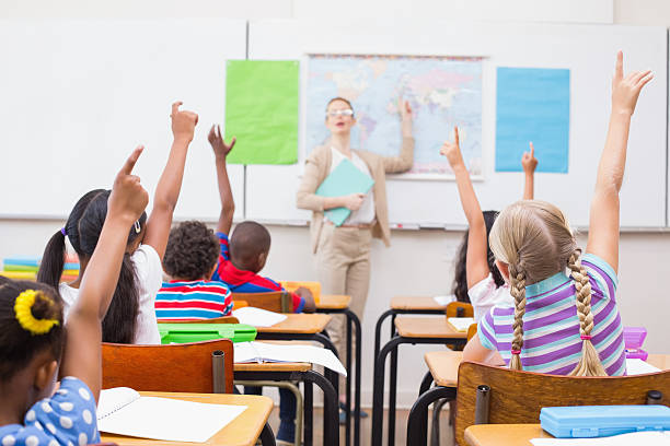 istock Pupils raising hand during geography lesson in classroom 472977084