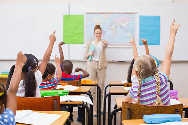 istock Pupils raising hand during geography lesson in classroom 472977086