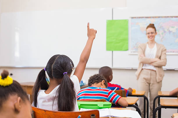 istock Pupils raising hand during geography lesson in classroom 472977090