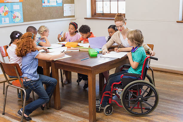 Pretty teacher helping pupils in classroom