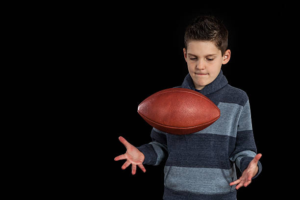istock Boy Tossing Up Fooball and Catching 472980416