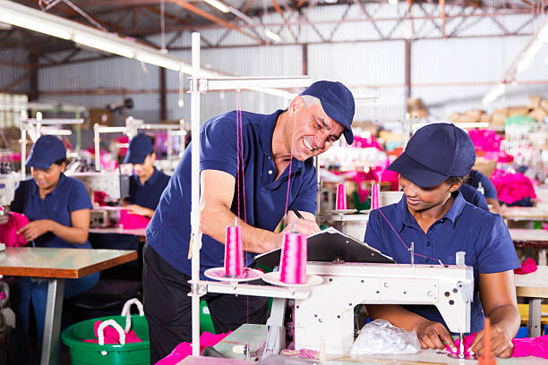 istock senior textile factory supervisor taking score from machinist 472980778