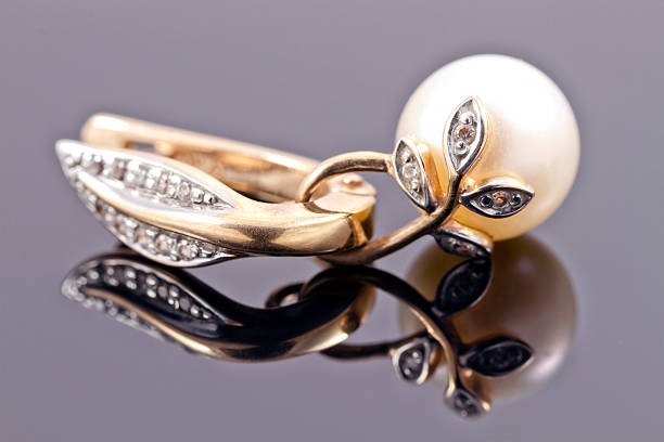 istock decorative gold earring with pearls on the reflecting surface 472989556