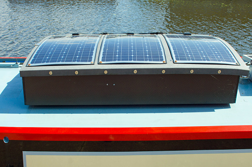 Solar photovoltaic panels on the roof of a narrowboat on the river at Ely.