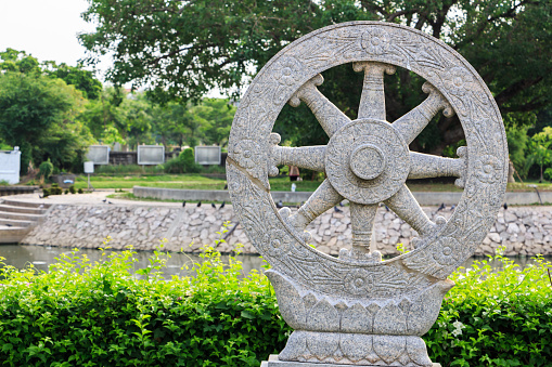 wheel of dhamma in garden in temple of thailand.