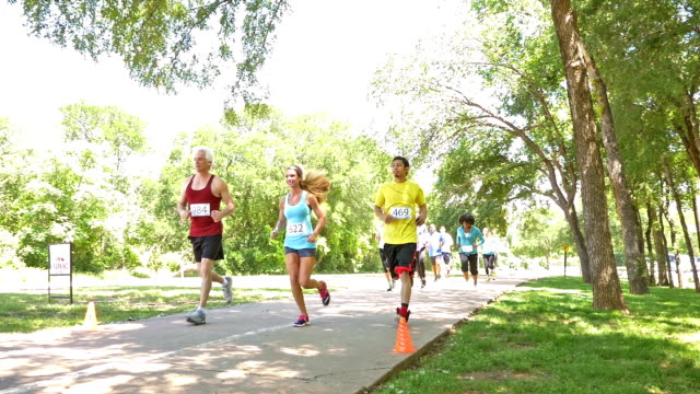 Diverse race competitors running past during marathon or 5k charity race