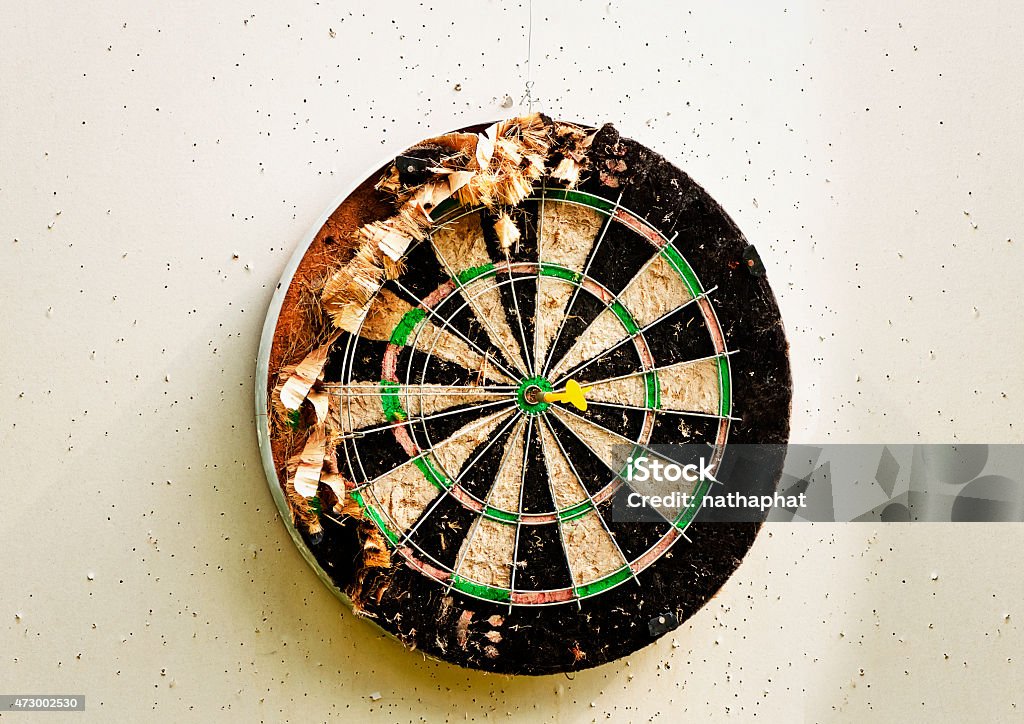 Old dart board Old dart board  with yellow dart  in bullseye 2015 Stock Photo