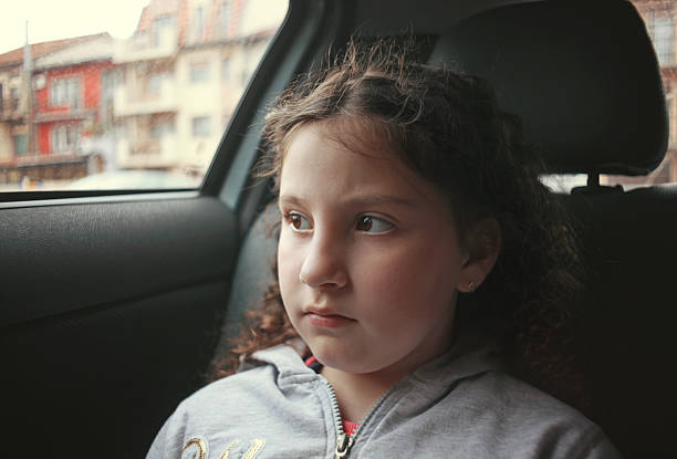 istock Kid in car waiting, serious expression 473007176