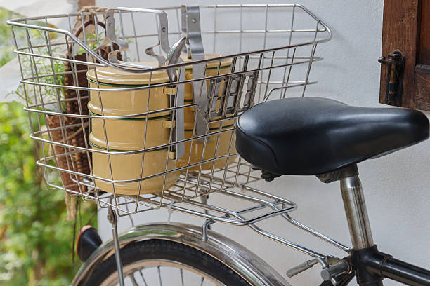Vintage Dutch black cargo transport bicycle with crate carrier in front of old wooden crates and concrete wall
