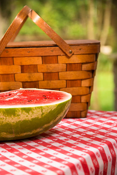 スライスのスイカ屋外でのピクニックテーブルを配しております。夏ます。バスケットます。 - picnic watermelon tablecloth picnic table ストックフォトと画像