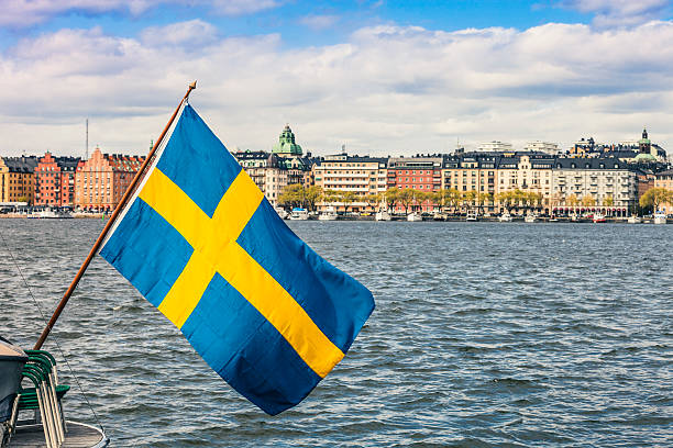 Stockholm view to downtown with a Swedish flag Stockholm view to downtown with a Swedish flag on the waterfront. sweden flag stock pictures, royalty-free photos & images