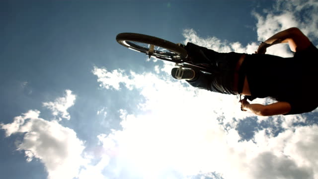 HD Super Slow-Mo: Dirt Backflipping Against Cloudy Sky