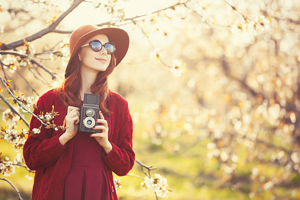 istock women with camera in blossom apple tree garden 473034376