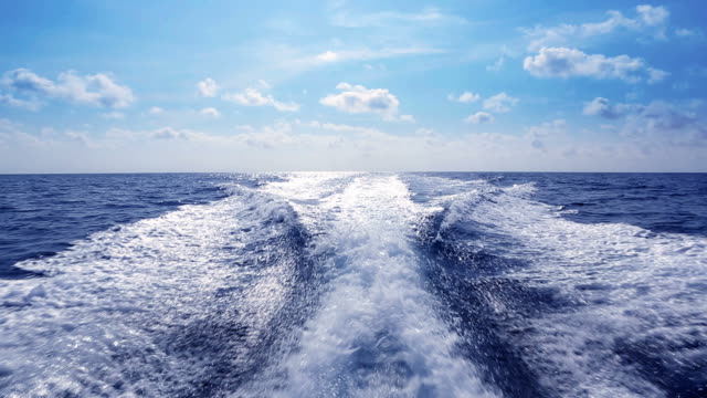 Boat wake boating fast on blue Mediterranean
