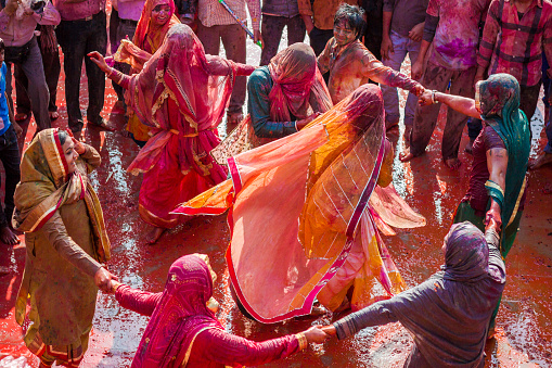 Nandgaon, India - March 10, 2014 : Senior Indian women celebrate Holi dancing at Krishna temple in Nandgaon.