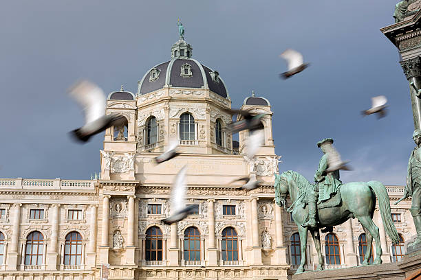 Vienna, Austria - December 17, 2014: Pigeons fly by Naturhistorisches Museum and Maria Theresa Monument at Maria-Theresien-Platz in Vienna during the day.
