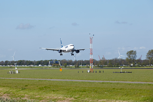 Amsterdam, The Netherlands - May 7, 2015: An Airbus A318-111 of Tarom lands at Amsterdam Airport Schiphol (The Netherlands, AMS) on May 7, 2015. The name of the runway is Polderbaan.