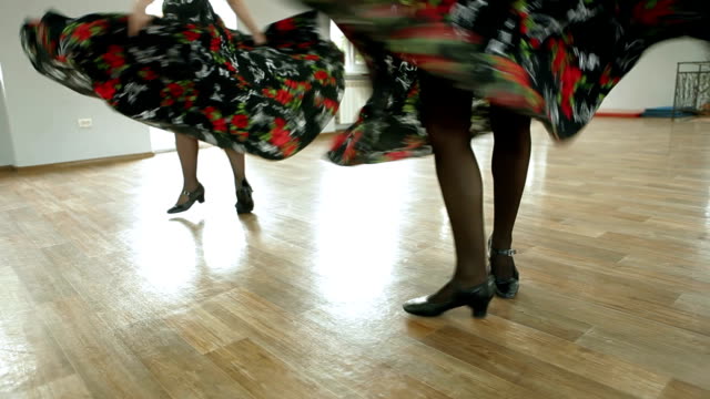 Two dancing women in long dresses